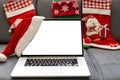 Laptop computer with white blank empty mock up screen on Merry Christmas table with presents gifts boxes in warehouse