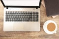 Laptop computer white blank screen with cup of coffee and notebook on work table. Flat lay Royalty Free Stock Photo