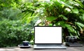 Laptop computer with white blank screen on wooden table with nature background Royalty Free Stock Photo