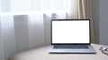 Laptop computer with white screen on comfortable sofa in bright living room. Royalty Free Stock Photo