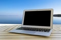 Laptop computer on wooden table. Front ocean view. Tropical island background. Open blank laptop computer empty space. Front view Royalty Free Stock Photo