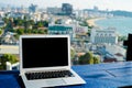 Laptop computer on wooden table with modern city view Royalty Free Stock Photo
