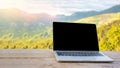 Laptop computer on wooden table terrace with beautiful outdoor background nature landscape scenery forest and mountain valley in Royalty Free Stock Photo