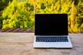 Laptop computer on wooden table terrace with beautiful outdoor background nature landscape scenery forest and mountain valley in Royalty Free Stock Photo