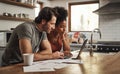 Laptop, couple and financial planning in a kitchen with documents for budget, savings and paying bills. Interracial Royalty Free Stock Photo