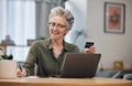 Laptop, credit card and senior woman paying her bills, debt or mortgage with online banking. Elderly lady planning a Royalty Free Stock Photo