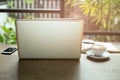 Laptop and cup of coffee and cell phone with books and pen on wooden table