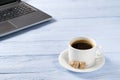 Laptop with cup of coffee on light blue old wooden table. Notebook with cup of fresh coffee in home office. Working from Royalty Free Stock Photo