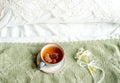 Laptop, a cup of tea,White bed and plaid. sunny morning and breakfast. work online in a comfortable home. cozy bright room Royalty Free Stock Photo