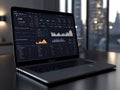 Laptop displaying business analytics dashboard on a dark glossy surface