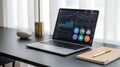Laptop displaying business analytics with notebook and pen on desk setup Royalty Free Stock Photo