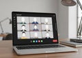 Laptop displaying a virtual meeting interface with nine participants, represented by avatars on a Royalty Free Stock Photo