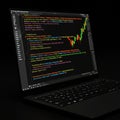 A laptop displays coding in a text editor, possibly JavaScript or similar, with colorful Royalty Free Stock Photo