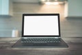 Laptop with empty blank screen on wooden tabletop with modern blur kitchen background