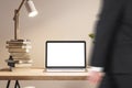 Laptop with empty screen on wooden desk, blurred movement in home office.