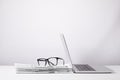 laptop and eyeglasses on heap of newspapers, on white Royalty Free Stock Photo