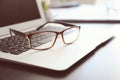 Laptop with eyeglasses on table prepared for business meeting in conference hall