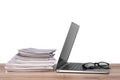 Laptop, glasses and stack of magazines on wooden table Royalty Free Stock Photo
