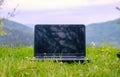 Laptop on grass. Laptop on green grass in park. Working outdoor. Blank screen. Laptop in nature background. Ecology Royalty Free Stock Photo