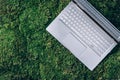 Laptop on green grass, moss background. Ecology travel, work outside office concept. Mindfulness, biophilic design Royalty Free Stock Photo