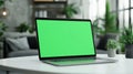 Laptop with green screen, chroma key mock up is on the table. Computer display close-up. Business mockup empty blank