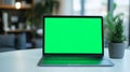 Laptop with green screen, chroma key mock up is on the table. Computer display close-up. Business mockup empty blank