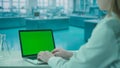 Laptop with Green Screen on Research Biochemistry lab Desk. Advertising area, workspace mock up. Royalty Free Stock Photo