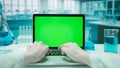 Laptop with Green Screen on Research Biochemistry lab Desk. Advertising area, workspace mock up. Royalty Free Stock Photo