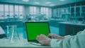 Laptop with Green Screen on Research Biochemistry lab Desk. Advertising area, workspace mock up. Royalty Free Stock Photo