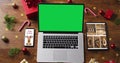 Laptop with green screen on screen, with smartphone,tablet and christmas decorations Royalty Free Stock Photo