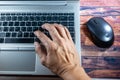 Laptop with a hand while typing or encoding and moving mouse. Business concept, office concept, work from home concept Royalty Free Stock Photo