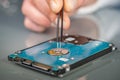 Laptop hard drive and technician using tweezers Royalty Free Stock Photo