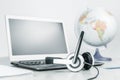 Laptop with headphones on white desk amd globe Royalty Free Stock Photo