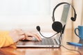 Laptop with headphones on wooden desk. Female hands Royalty Free Stock Photo