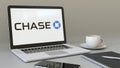 Laptop with JPMorgan Chase Bank logo on the screen. Modern workplace conceptual editorial 3D rendering