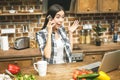 Laptop on kitchen table and cooking girl. Food blogger concept. Surprised girl Royalty Free Stock Photo