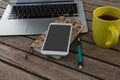 Laptop, mobile phone, dairy, pen and coffee on wooden plank Royalty Free Stock Photo