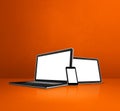 Laptop, mobile phone and digital tablet pc on orange office desk Royalty Free Stock Photo