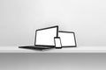 Laptop, mobile phone and digital tablet pc on white concrete wall shelf. Horizontal background Royalty Free Stock Photo