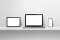 Laptop, mobile phone and digital tablet pc on white concrete wall shelf. Horizontal background Royalty Free Stock Photo