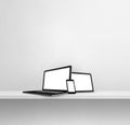 Laptop, mobile phone and digital tablet pc on white concrete wall shelf. Square background Royalty Free Stock Photo