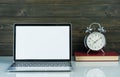 Laptop mockup and alarm clock with wood background on the work table Royalty Free Stock Photo