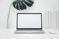 Laptop mockup with blank screen on white table with mouse. Home interior or office background