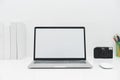 Laptop mockup with blank screen on white table with mouse. Home interior or office background