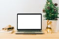 Laptop with mockup blank screen on wooden table with Christmas gift, fir tree on white background. Computer with Mock up