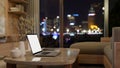A laptop mockup on a luxury marble coffee table in a modern apartment living room at night Royalty Free Stock Photo