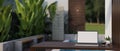 A laptop mockup on a table in a beautiful tropical home\'s outdoor terrace or courtyard Royalty Free Stock Photo