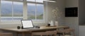 A laptop mockup on a wooden dining table by the window in minimal white kitchen Royalty Free Stock Photo