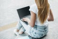 Laptop mockup. Young student girl uses laptop with white screen, sitting on stairs and looking at empty black monitor Royalty Free Stock Photo