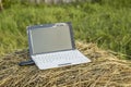 laptop with modem lies on a haystack in a meadow evening at sundown Royalty Free Stock Photo